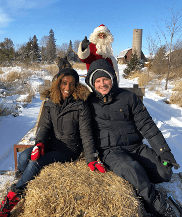 Photo of young couple and Santa taking a sleigh ride at Fallowfield Tree Farm