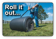 Picture of a fellow using a heavy roller to level the sod and ensure the roots make solid, consistent contact with the prepared topsoil underneath
